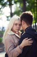 Girl put her head on his head, love in autumn park, teen couple. Concept of relationship teenagers photo