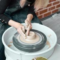 Woman making ceramic pottery on wheel, hands close-up, creation of ceramic ware. Handwork, craft, manual labor, buisness. Earn extra money, turning hobbies into cash and turning passion into job photo