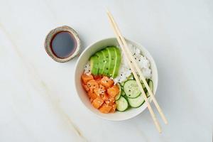 salmon poke bowl with fresh fish, rice, cucumber, avocado photo