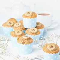 Banana muffin, cupcakes in blue cake cases paper, side view, white concrete table photo