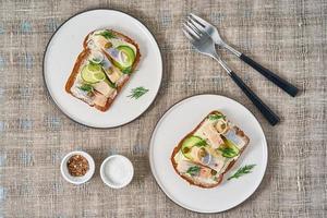 Herring smorrebrod - traditional Danish sandwiches. Two plate with black rye bread photo