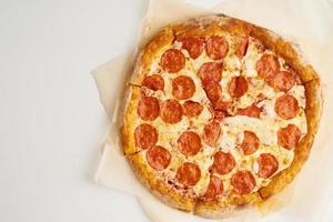 pepperoni de pizza italiana en la vista superior de papel para hornear foto