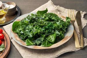 Salad kale, leaf cabbage, cos lettuce green mixture in plate. Undressed fresh leaves. Vegan photo
