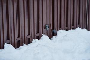 Metal Fence and snow in countryside, gate with padlock, side view photo