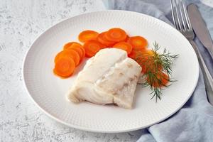 Boiled codfish with carrot and dill on white plate, fodmap dash paleo diet photo