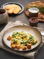 Scrambled eggs with spinach, cup of tea photo