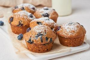 Blueberry muffin, side view, close up. Cupcakes with berries on white concrete table