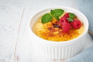 Crema catalana, Spanish dessert with berries in white ramekin, side view, fodmap recipe photo