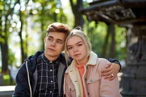 novia y novio enamorándose, sentados y soñando en el parque cerca de la fuente en otoño. concepto de amor y felicidad foto