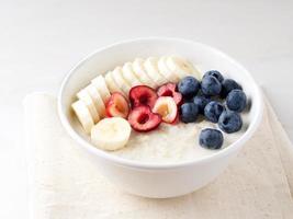 tazón grande de avena sabrosa y saludable con frutas y bayas para el desayuno, la comida de la mañana foto