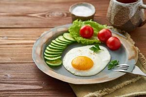 huevo frito, verduras. dieta paleo, keto, fodmap. vista lateral. concepto de dieta saludable, placa azul