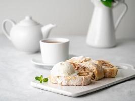 Apple strudel with ice cream and cinnamon. Baked cake and tea, delicious dessert photo