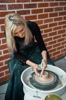 Woman making ceramic pottery on wheel. Concept for woman in freelance, business. Handcraft product. Earn extra money, side hustle, turning hobbies into cash and passion into job photo