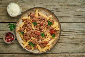 Bolognese pasta. Fusilli with tomato sauce, ground minced beef. Traditional italian cuisine. Top view, copy space