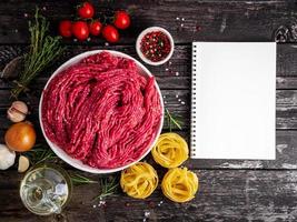 Mince beef, ground meat with ingredients for cooking on dark blue photo