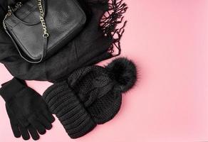 Flat lay winter or autumn warm woman accessories - black knitted scarf, hat, photo