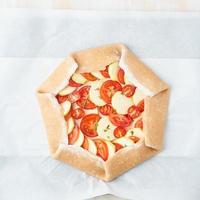 Step by step recipe. Raw homemade galette with vegetable. Top view, white wooden table photo