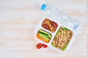 lonchera vegana, agua en botella, espacio para copiar. menú vegetariano saludable, pérdida de peso