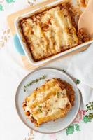 Cannelloni pasta with filling of ground beef, tomatoes, baked with bechamel photo