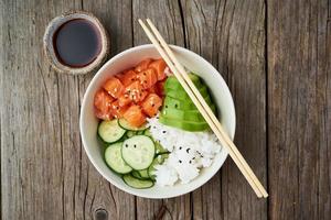 salmon poke bowl with fresh fish, rice, cucumber, avocado photo
