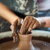mujer haciendo cerámica en rueda, primer plano de manos, creación de cerámica.