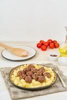 Swedish meatballs with fusilli paste on white wooden table, copy space, side view photo