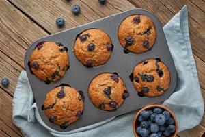 muffin de arándanos en bandeja, vista superior. pastelitos con bayas en un plato para hornear foto