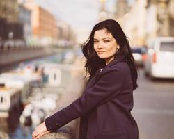 retrato f hermosa morena inteligente que camina por la calle de san petersburgo en el centro de la ciudad. encantadora mujer pensativa con cabello largo y oscuro vaga sola, inmersa en pensamientos foto