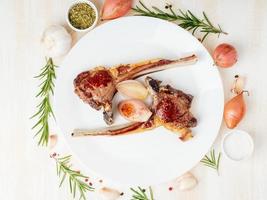 Fat fried lamb ribs, paleo, lchf diet on white plate with vegetable photo