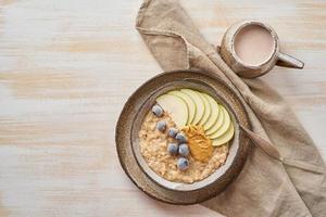 avena, papilla saludable en un tazón grande con frutas y bayas para el desayuno, taza de cacao. foto