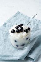 Vegan Coconut Rice Pudding with blueberry, gluten free dessert, side view, vertical. photo