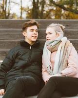 Teenage love concept. Cute brunette guy young blonde girl photo