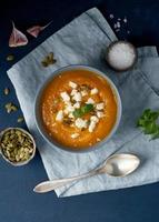 Pumpkin cream soup with feta cheese, autumn homemade food, dark blue background photo