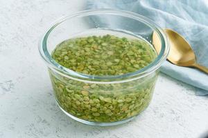 remojar el cereal de guisantes verdes en agua para fermentar los cereales y neutralizar el ácido fítico. foto