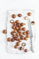 Plate with almonds in endocarp, whole and chopped open nuts in bulk on a cutting board photo