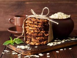 Homemade oatmeal cookies with banana, oats, nuts, eggs and flour free on table, side view. photo