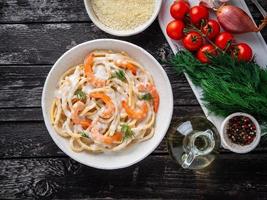 italian pasta spaghetti with shrimps, bechamel sauce and chopped dill photo