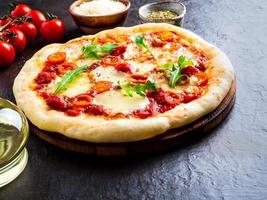 hot homemade Italian pizza margherita with mozzarella and tomatoes photo