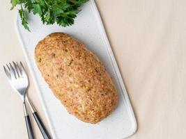 Terrine, meat loaf. Baked Turkey ground meat. Traditional French and American dish. Top view, copy space, white marble background photo