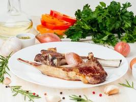 Fat fried lamb ribs, paleo, lchf diet on white plate with vegetable photo