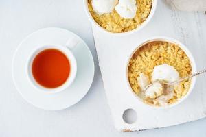Apple crumble with ice cream, streusel. Morning breakfast with tea on a light gray table photo