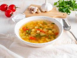 Healthy spring vegetable dietary vegetarian soup, white wooden background, side view, close up photo