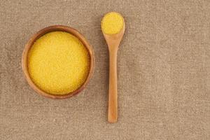 Yellow corn flour in wooden bowl on rustic linen napkin. Ingredients for Polenta photo