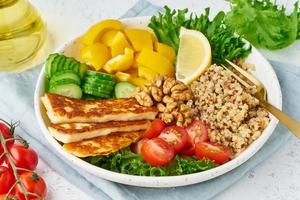 Buddha bowl with halloumi, quinoa, salad lettuce, vegeterian food, white background, top view photo