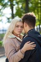 Guy and girl are standing embracing. First love, teenage love, new feelings and relationships. Autumn, Park photo