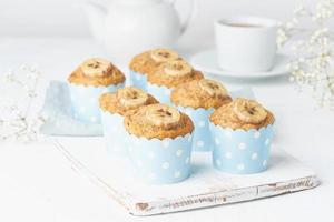 muffin de plátano, magdalenas en papel de cajas de pastel azul, mesa de hormigón blanco