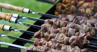 Barbecue shashlik kebab with winglets in chargrill semifinished on skewer side view closeup photo