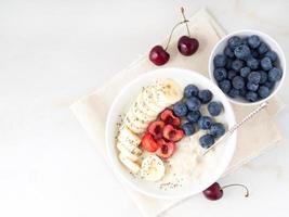 Large bowl of tasty and healthy oatmeal with fruits and berry for Breakfast, morning meal. Top view, copy space photo