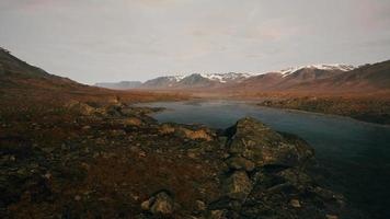 Atmospheric landscape with mountain lake among moraines in rainy weather video