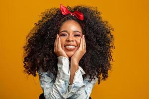 retrato de belleza de mujer afroamericana con peinado afro y maquillaje glamuroso. mujer brasileña. raza mixta. Pelo RIZADO. peinado fondo amarillo foto